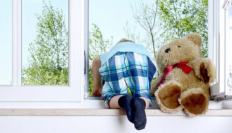 Kind klettert aus Fenster